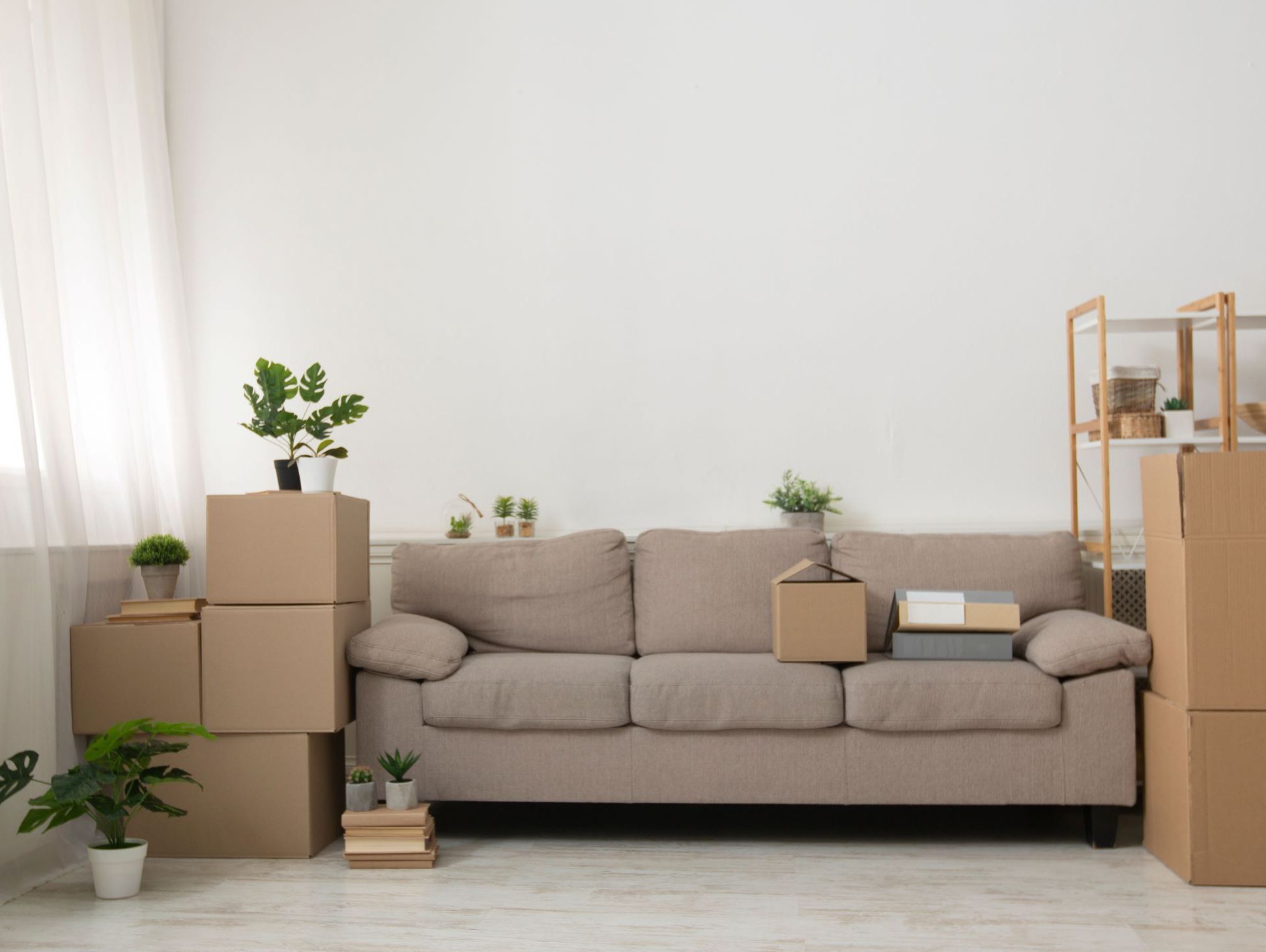 Vardagsrum med flyttlådor och soffa.